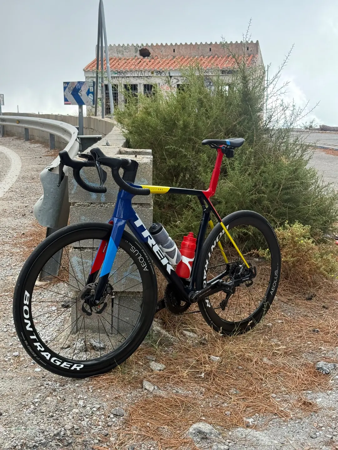 Road bike resting against a wall at a mountain pass beside an old roadside house